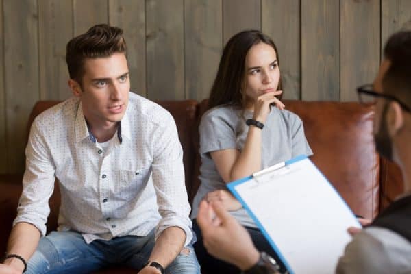 Mad husband discussing family problems with psychologist during